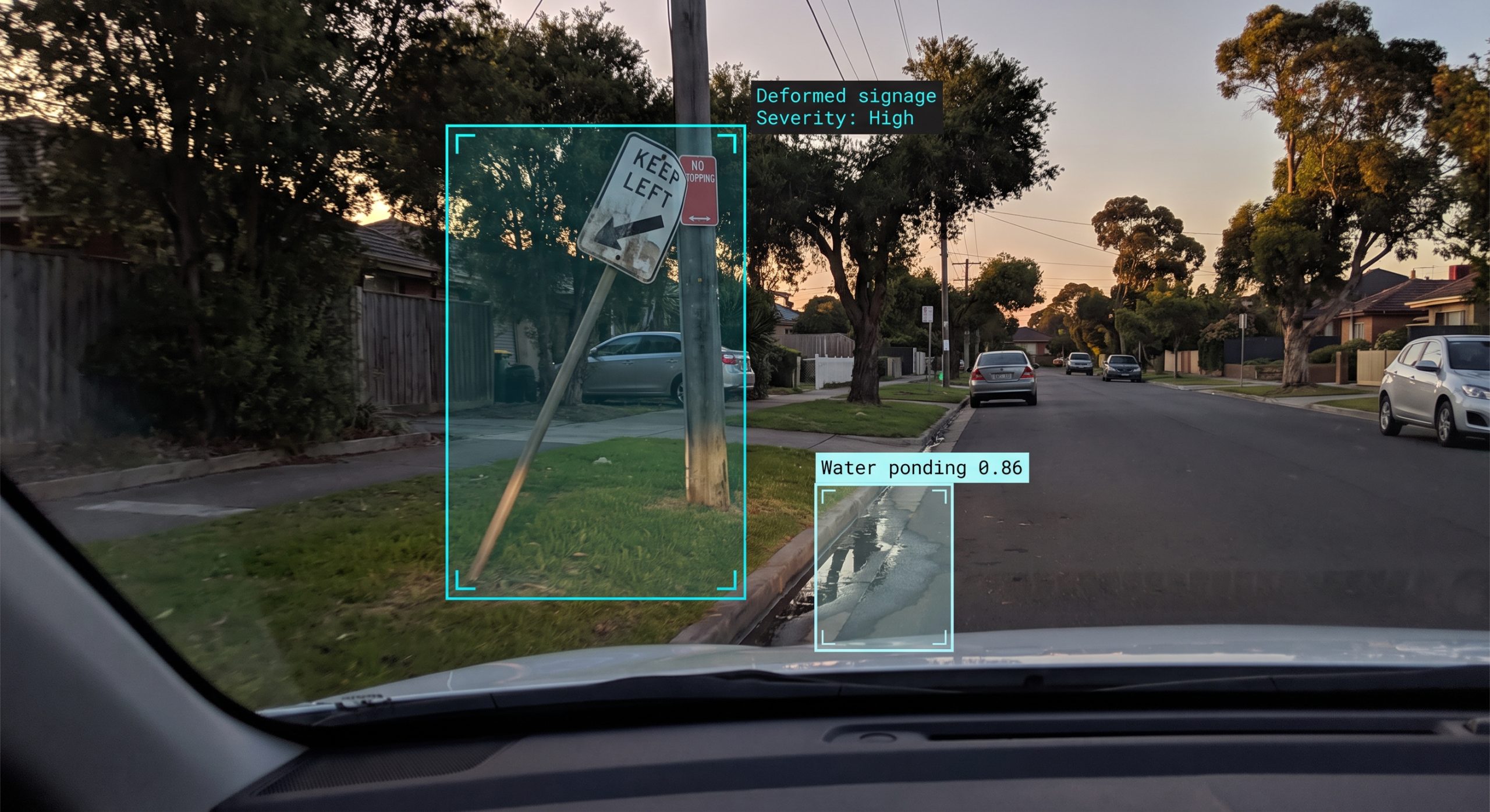 AI road condition assessment flagging deformed street signage and kerb-line water ponding on a council street at dusk